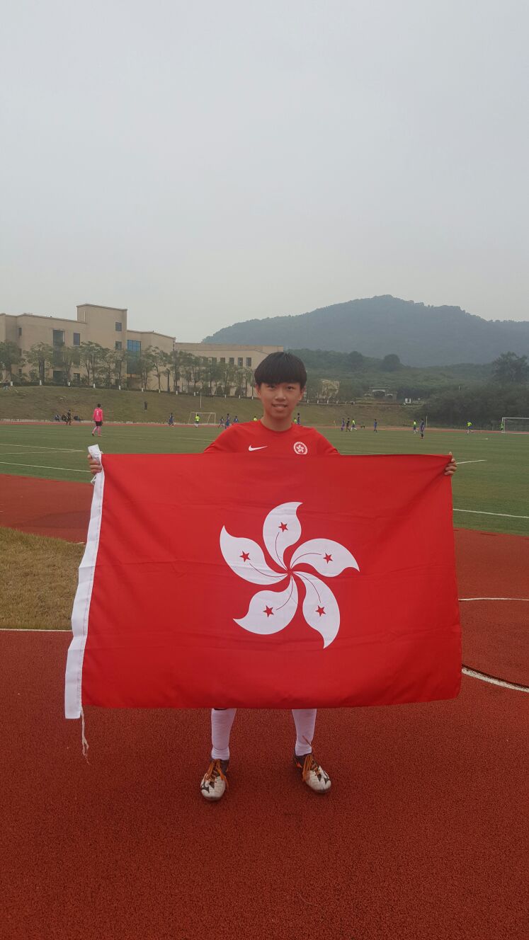 A young Bill Ki holding the Hong Kong flag after representing the Hong Kong U18 National Team