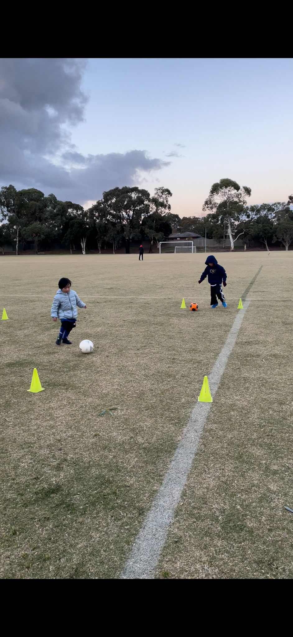 Elevate Football Academy kids dribbling through cone drill