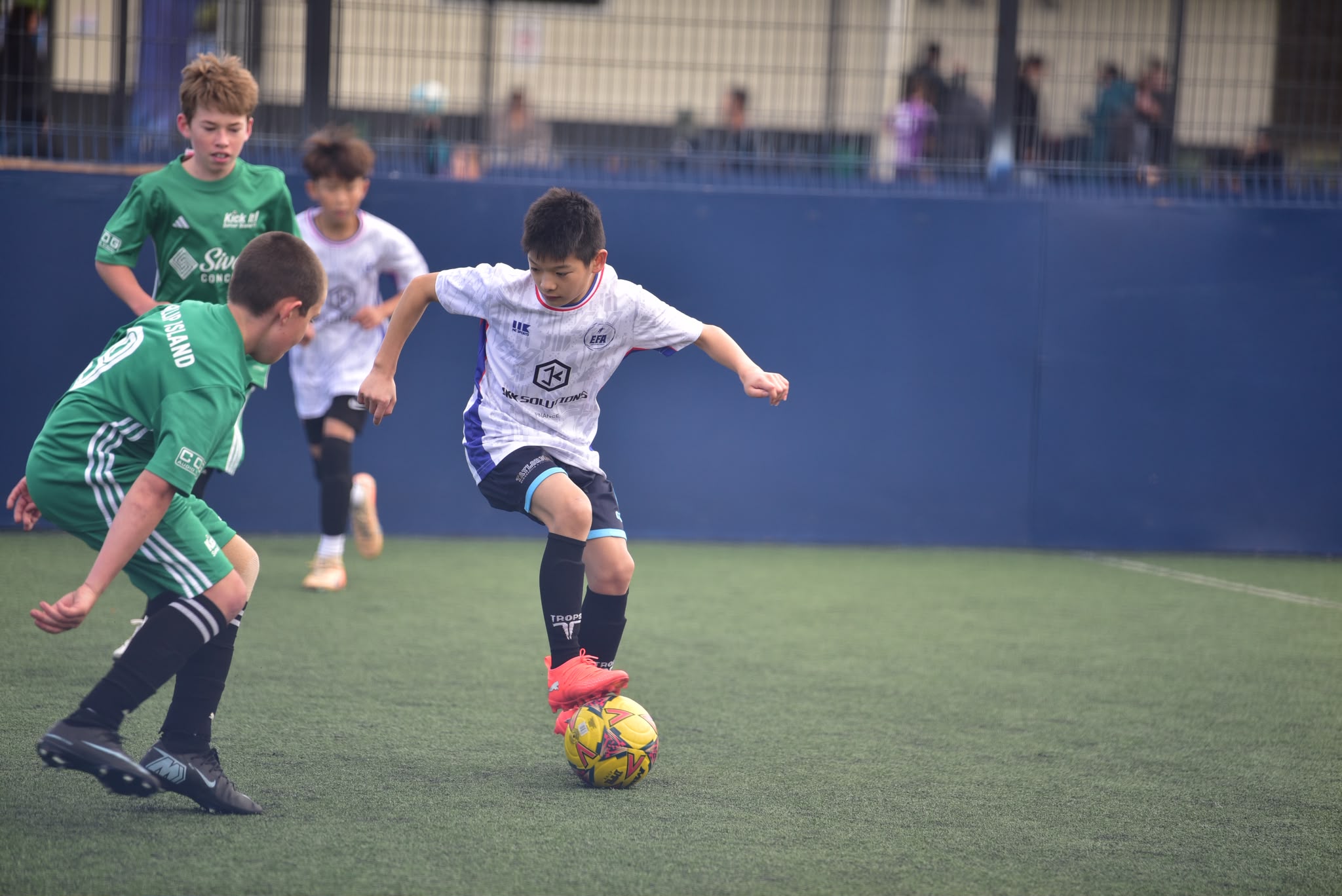 EFA player taking on defenders during a friendly match